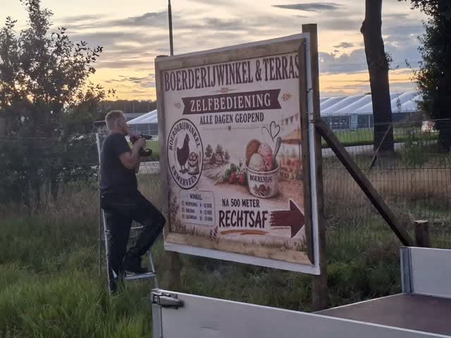 Het bord van Boerderijwinkel Ermerveen langs de weg